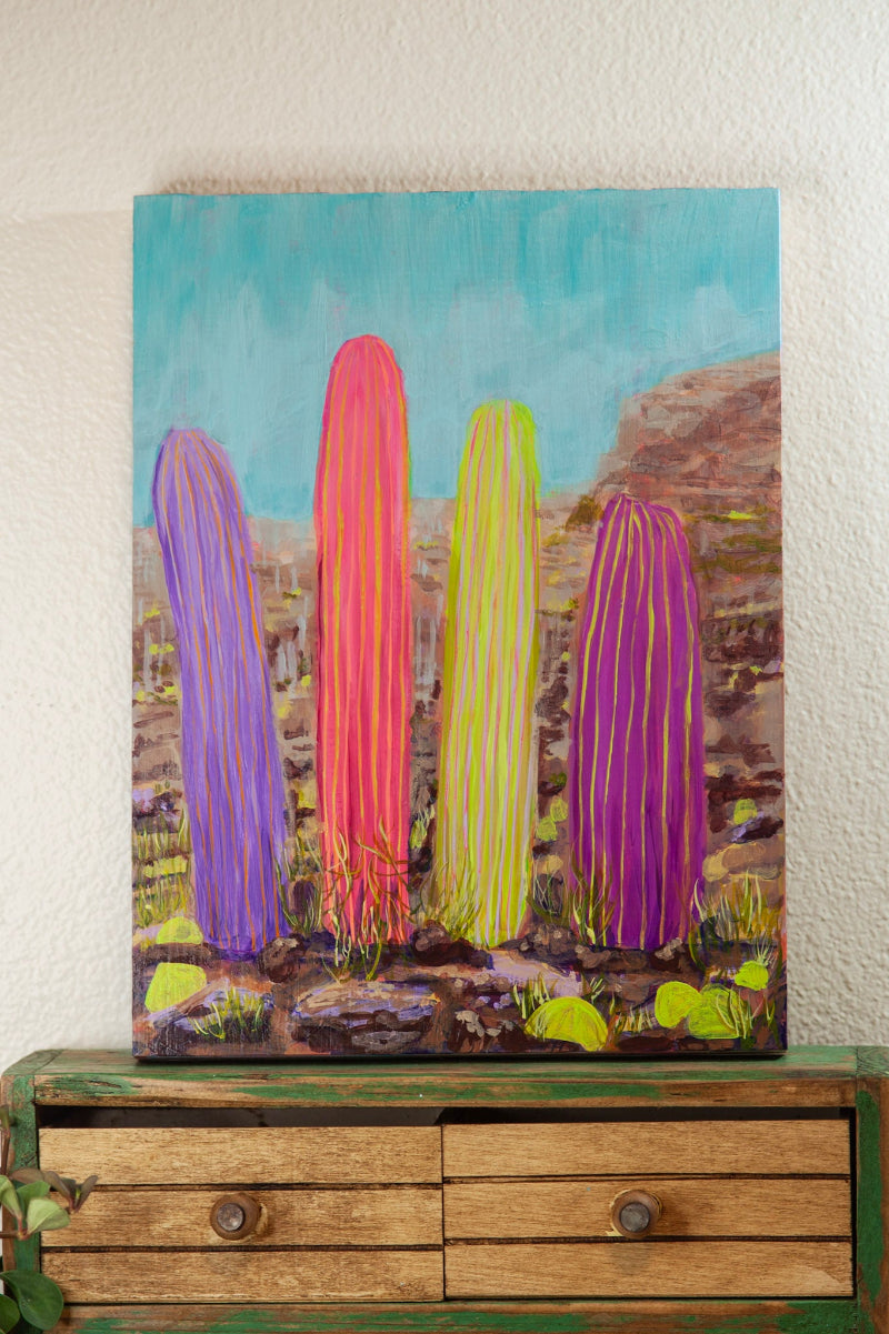 Colorful cactus painting on a wooden dresser against a white wall